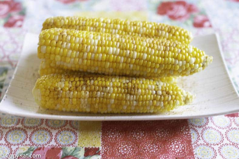 Fresh corn has been boiled and topped with butter and old bay seasoning