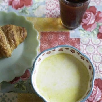 A bowl of homemade Dixie Stampede Cream of vegetable soup and a croissant.