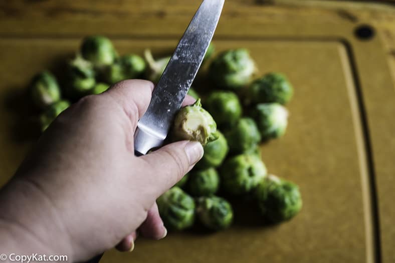 Cutting off the stem of a Brussel Sprouts with a paring knife