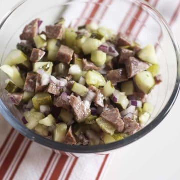 salami salad made with salami, onions, pickles, and olive oil