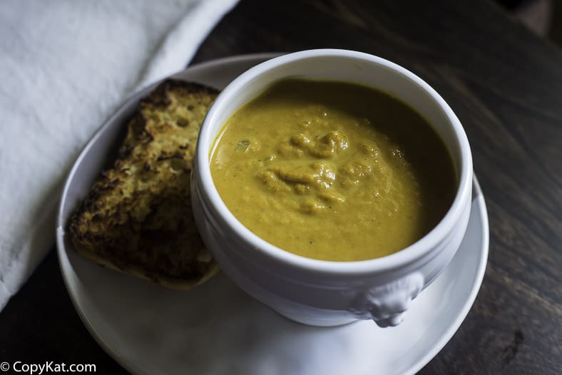 curried pumpkin soup in a bowl servied with garlic bread
