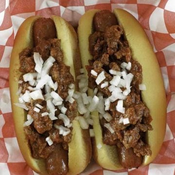 chili con carne on top of hot dogs