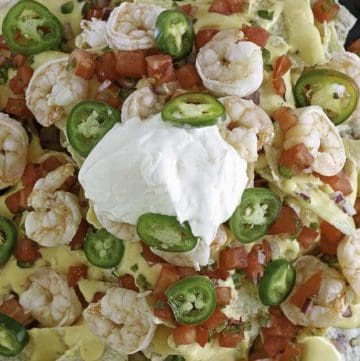 Cheesy nachos with shrimp, cheese, sour cream and more