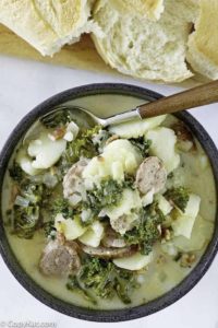 a bowl of potato and sausage soup with kale