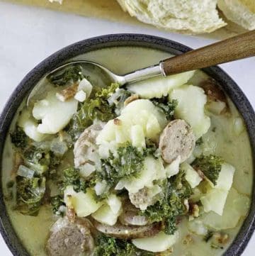 a bowl of potato and sausage soup with kale