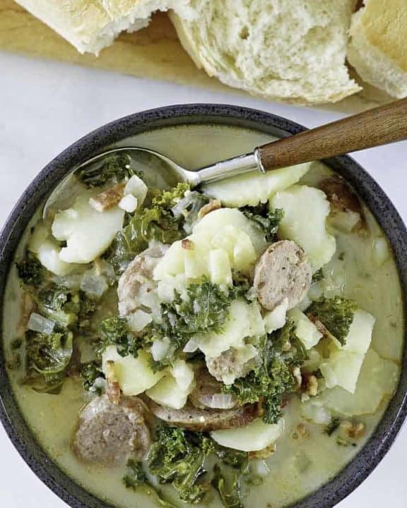 a bowl of potato and sausage soup with kale