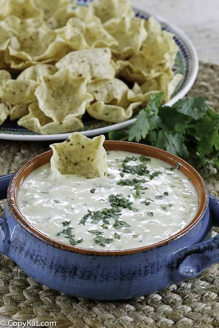 a bowl of white queso dip and tortilla chips