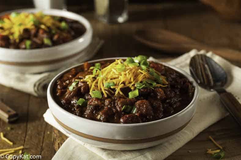 a bowl of hearty chili topped with cheese and green onions