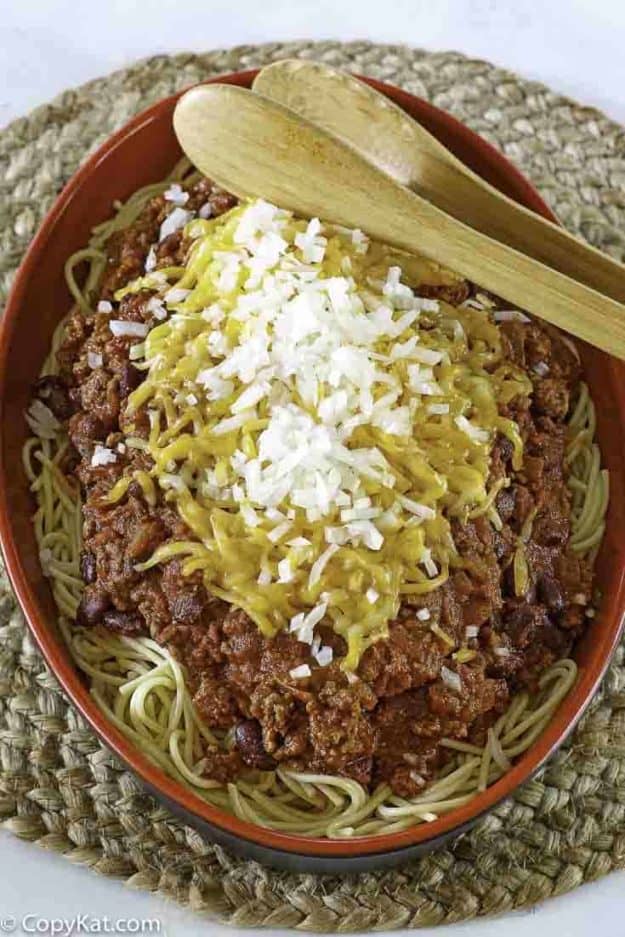 a plate of five way chili with spaghetti, chili, cheese, onions, and more