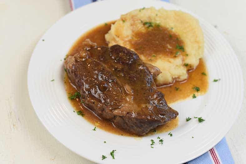 pot roast with mashed potatoes and gravy on a plate