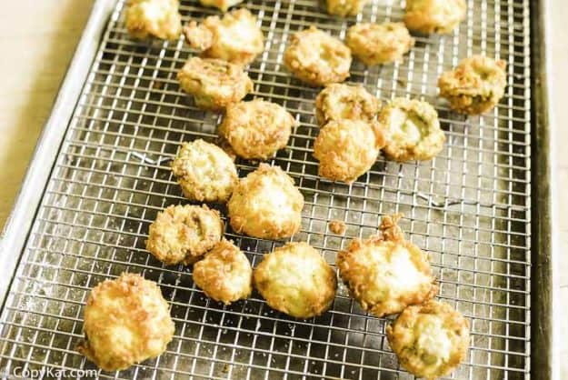 draining fresh fried mushrooms on a wire rack