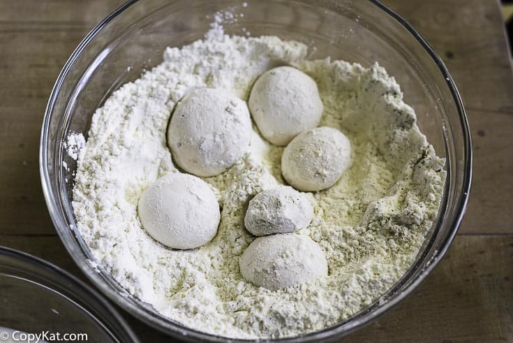 fresh mushrooms being dusted with seasoned flour