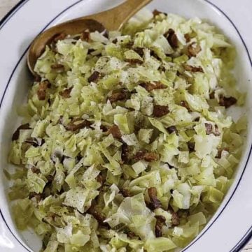 a plate of boiled cabbage with bacon