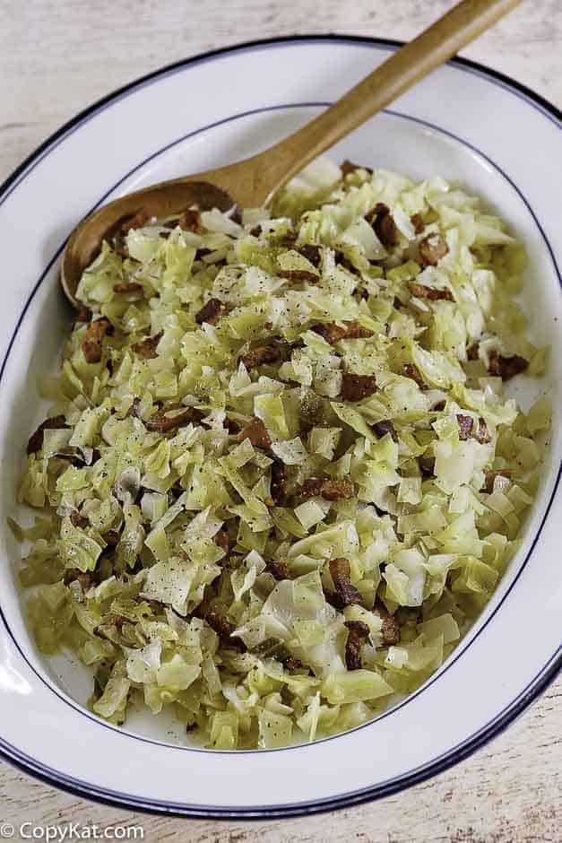 a plate of boiled cabbage with bacon