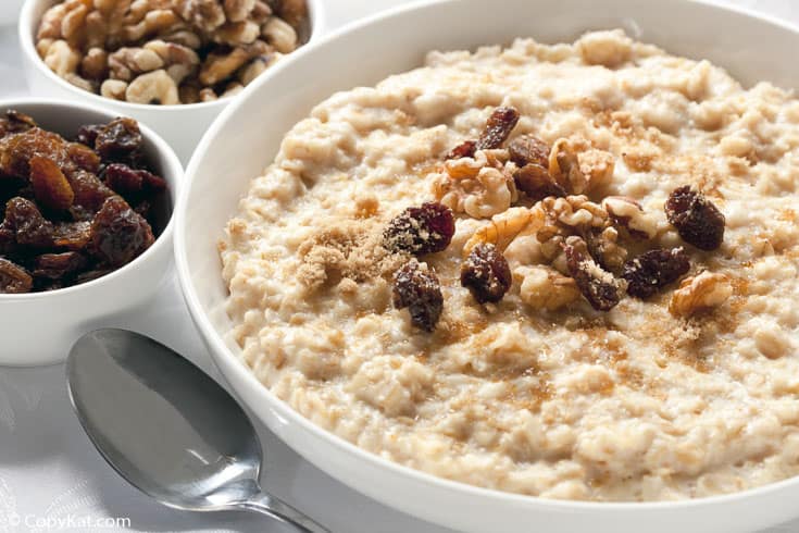 a bowl of oatmeal with raisins, walnuts, and brown sugar