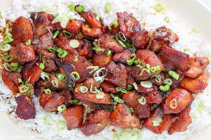 a platter of bourbon chicken on top of white rice