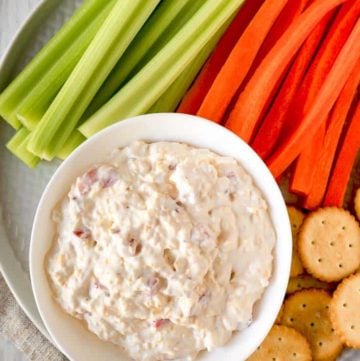 old fashioned pimento cheese spread on a platter with celery, carrots, and crackers