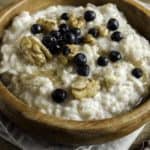 A bowl of oat bran porridge with walnuts and blueberries