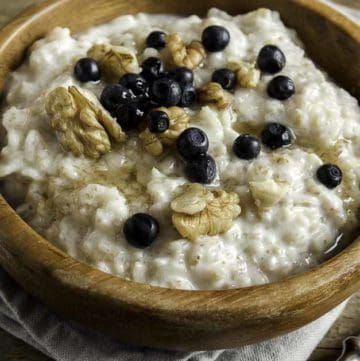 A bowl of oat bran porridge with walnuts and blueberries