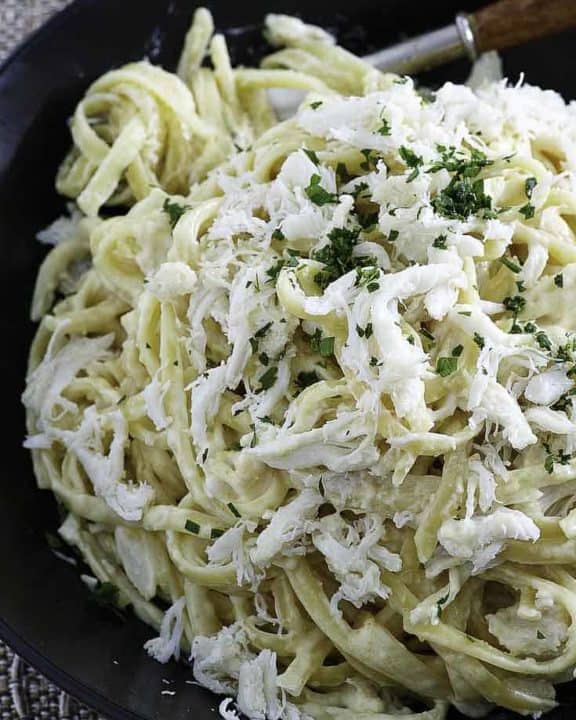 A plate of alfredo pasta with crab