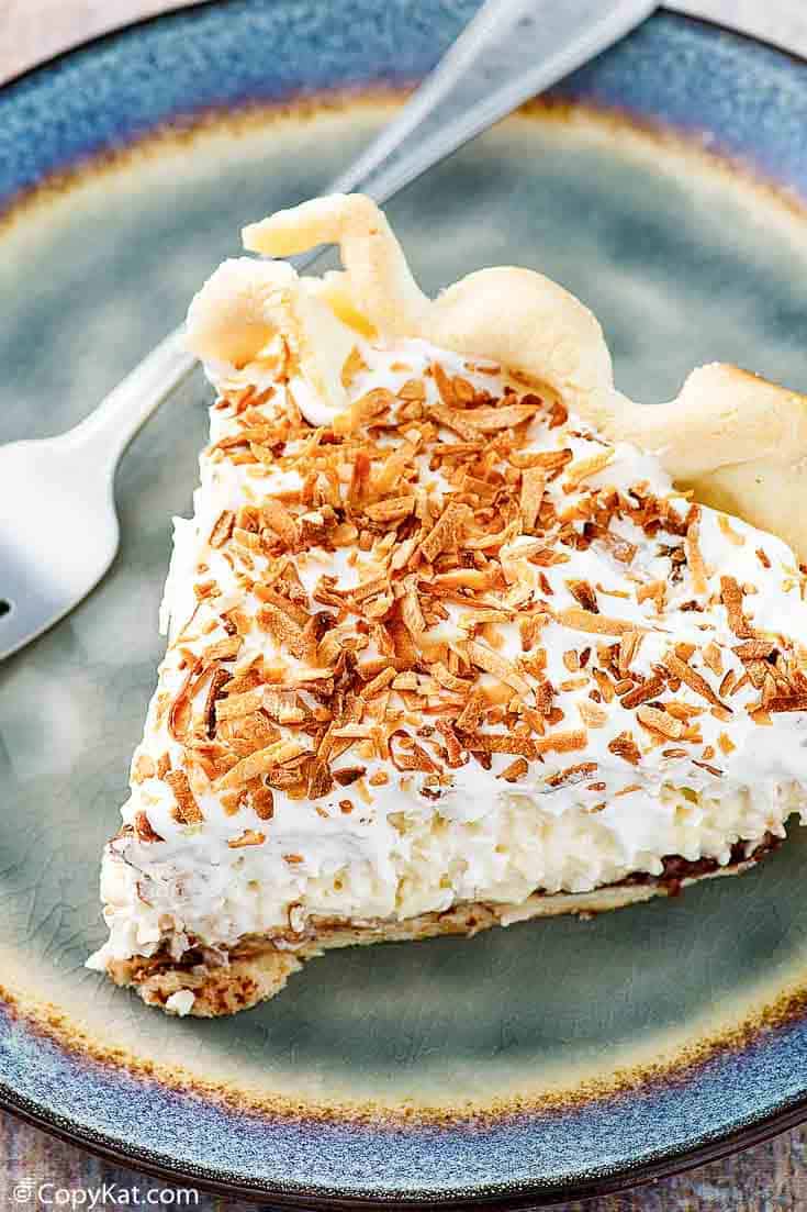 a slice of Bakers Square coconut cream pie on a blue plate