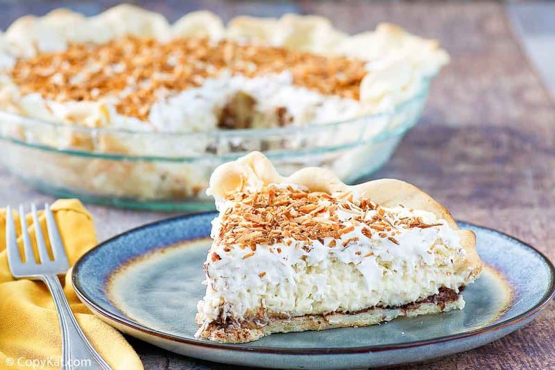 black bottom coconut cream pie slice with pie behind it