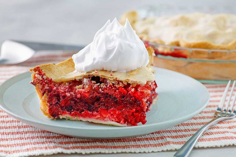 a slice of fruit of the forest pie on a blue plate