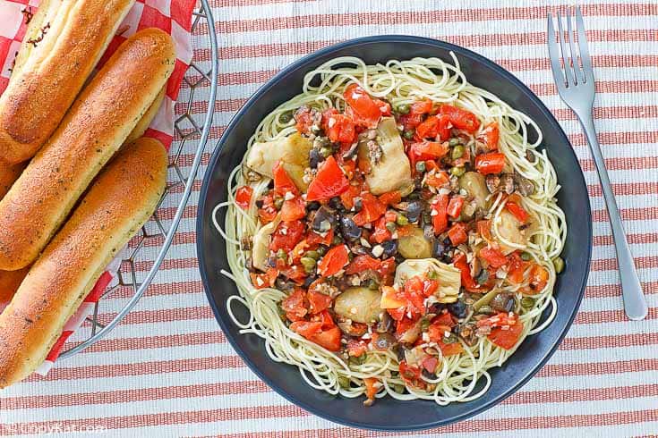 A bowl of homemade Johnny Carinos angel hair pasta with artichokes, olives, and tomatoes