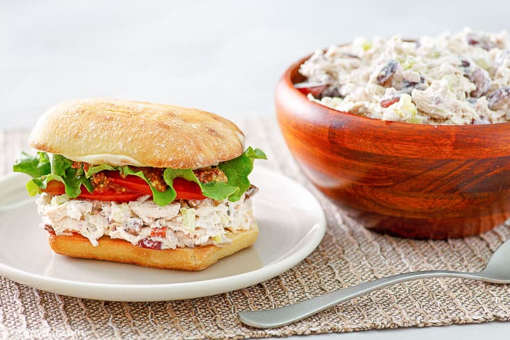 homemade Newks chicken salad in a sandwich and a wood bowl