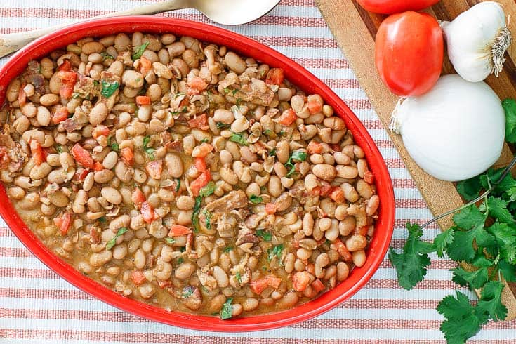 Frijoles a la Charra (Charro Beans) in a red serving dish