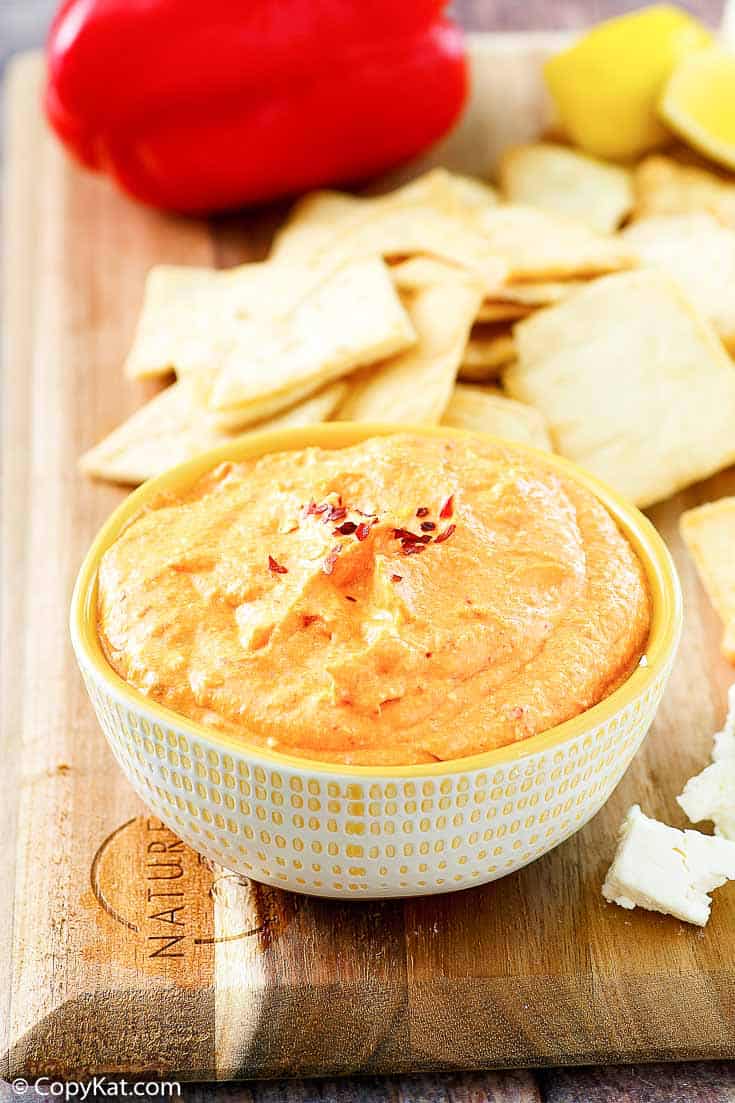 roasted red pepper dip in a bowl next to crackers