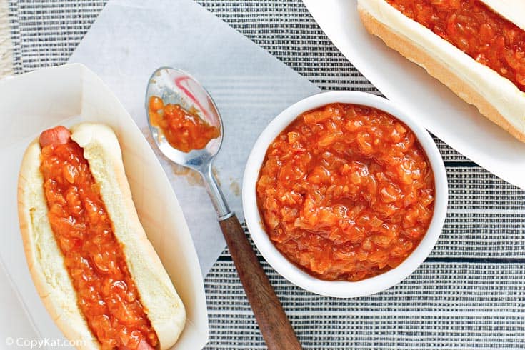 homemade Sabrett onion sauce in a bowl and on top of two hot dogs