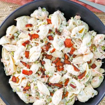 pasta salad with bacon, peas, carrots, and ranch dressing in a black bowl