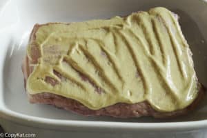mustard spread over a corned beef