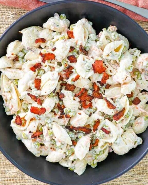 pasta salad with bacon, peas, carrots, and ranch dressing in a black bowl