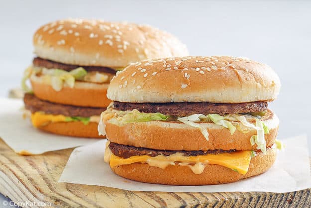 two homemade Big Mac burgers on a wood board