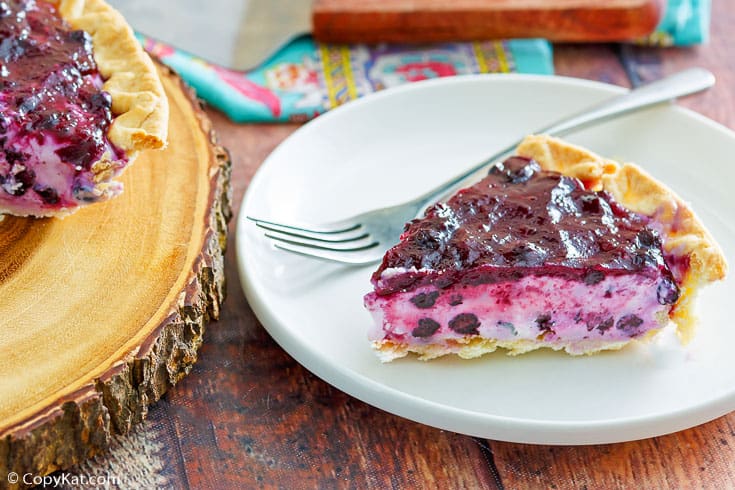 a slice of blueberry cream cheese pie and a fork on a plate