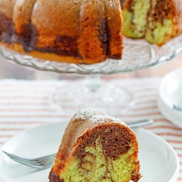 a slice of chocolate pistachio bundt cake in front of the cake on a stand