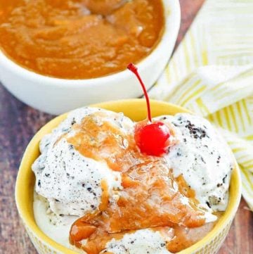 a bowl of cookies and cream ice cream with peanut butter sauce on top