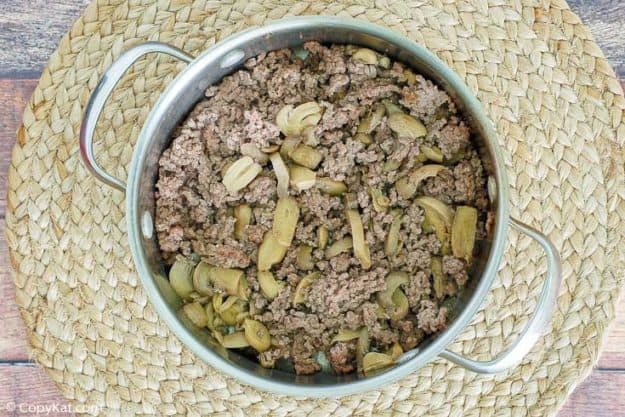 browned ground beef and mushrooms in a pan