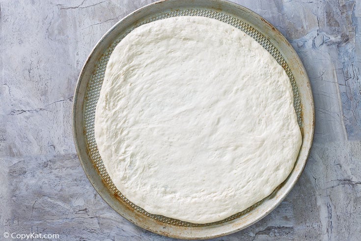 pizza dough on a pizza baking sheet