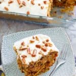 carrot cake with cream cheese frosting on a plate and in a baking dish
