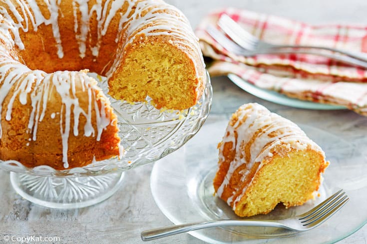 golden pound cake on a stand and a slice on a plate