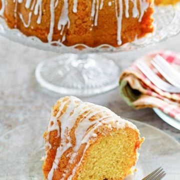 a slice of golden pound cake in front of the cake