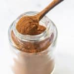homemade pumpkin pie spice mix in a small spoon on top of a spice jar