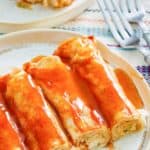 cream cheese chicken enchiladas with sauce on a plate