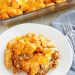 hamburger tater tot casserole in a baking dish and on a plate