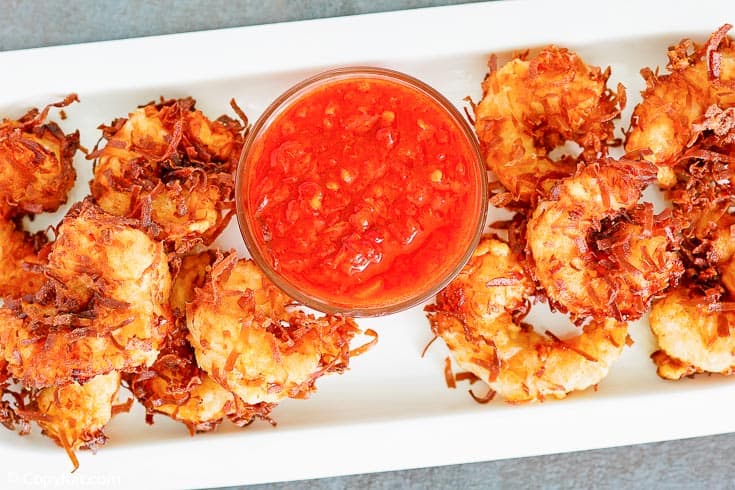 overhead view of coconut shrimp and dipping sauce on a platter