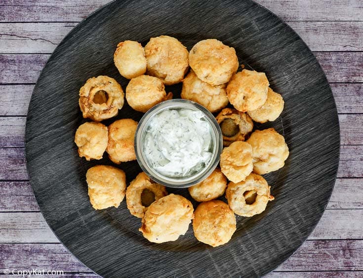 a platter of fried mushrooms with dipping sauce