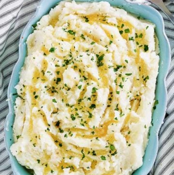 old fashioned mashed potatoes in a blue dish next to a serving spoon